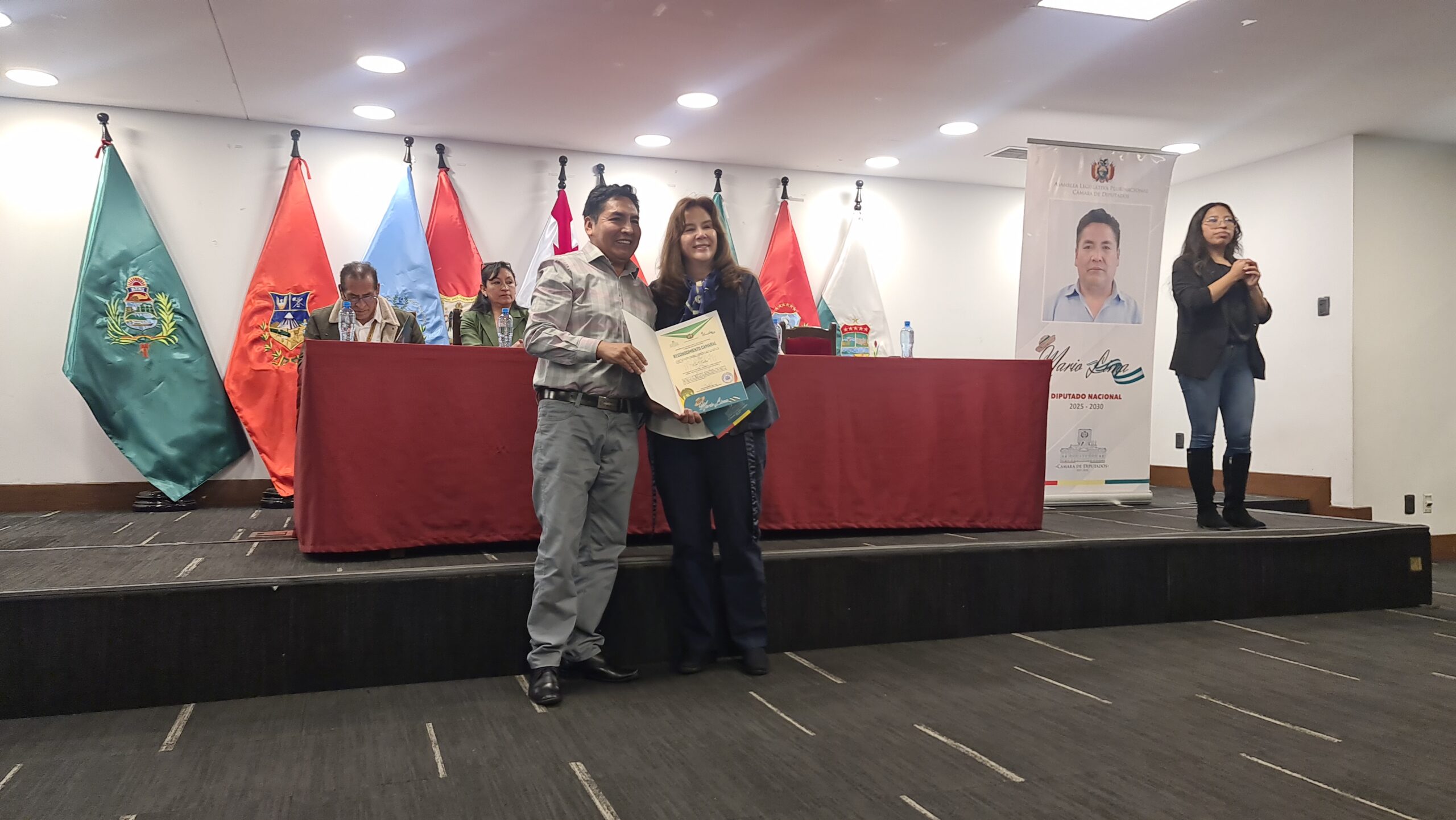 Mila Reynolds, directora ejecutiva de Unitas, recibe el reconocimiento. Foto: Sumando Voces
